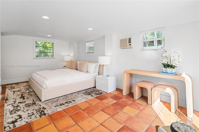 bedroom with a wall unit AC, multiple windows, and light tile patterned floors