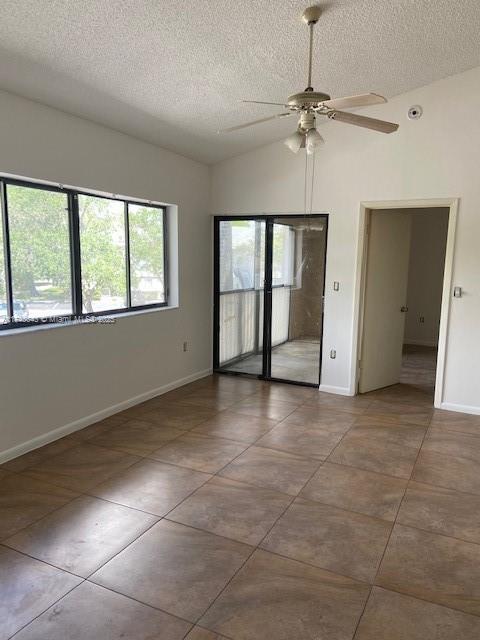 unfurnished bedroom featuring tile patterned flooring, a textured ceiling, and baseboards