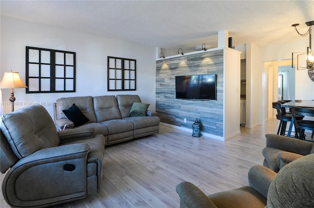 living room featuring a notable chandelier, wood-type flooring, and a textured ceiling