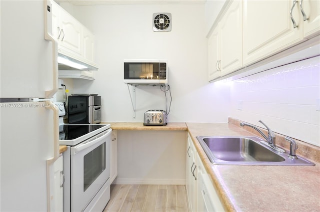 kitchen featuring white cabinetry, white appliances, light hardwood / wood-style floors, and sink