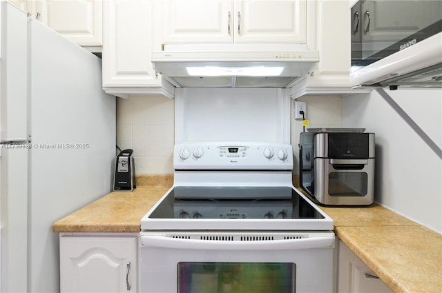 kitchen with white appliances, decorative backsplash, and white cabinets