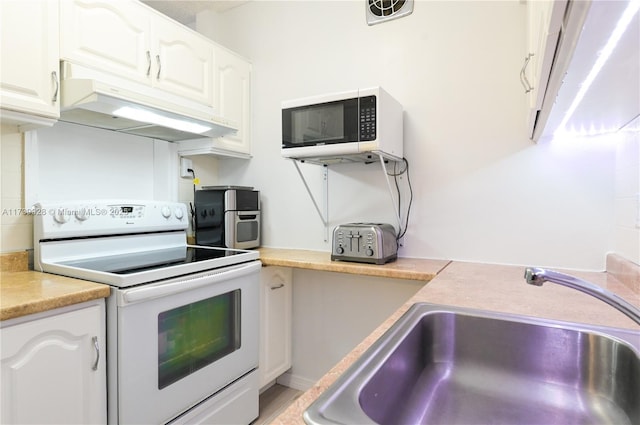 kitchen with sink, white appliances, and white cabinets