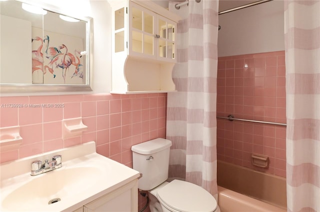 full bathroom featuring shower / tub combo with curtain, vanity, toilet, and tile walls