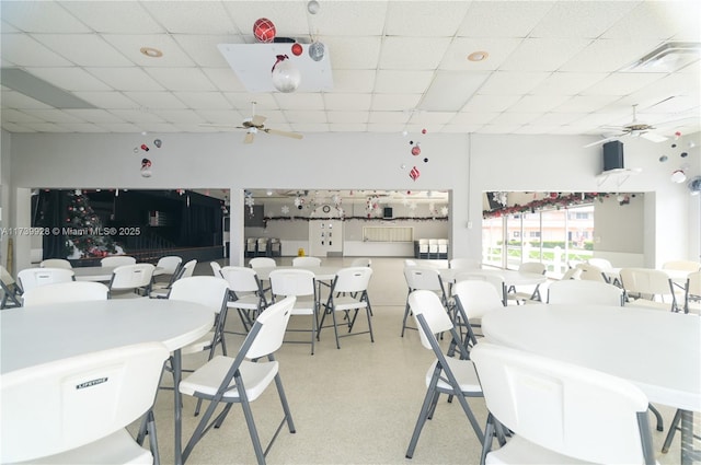 dining space featuring ceiling fan and a paneled ceiling