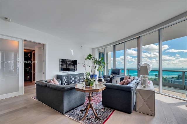 living room featuring floor to ceiling windows and light hardwood / wood-style floors