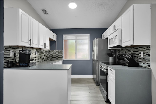 kitchen with white cabinetry, sink, electric range, and kitchen peninsula