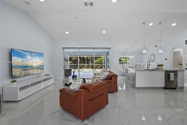 living room featuring high vaulted ceiling and sink