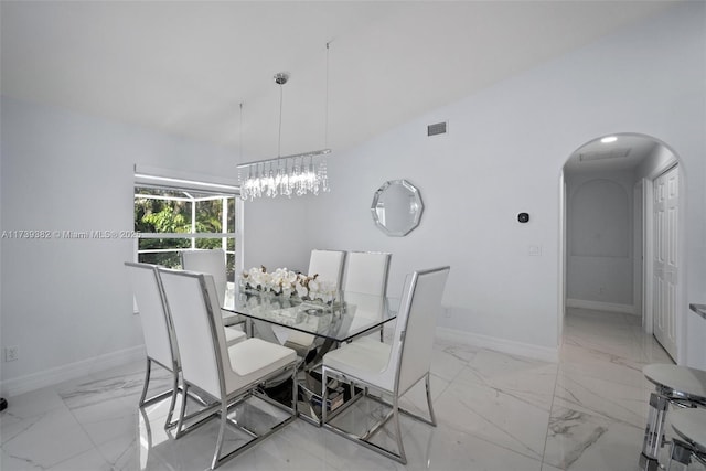 dining area with an inviting chandelier and vaulted ceiling