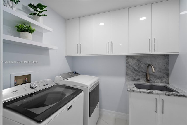 washroom with cabinets, sink, and independent washer and dryer