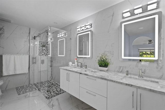 bathroom featuring a shower with door, ceiling fan, tile walls, vanity, and decorative backsplash