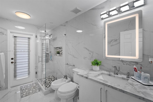 bathroom with a bidet, tile walls, vanity, a shower with shower door, and toilet