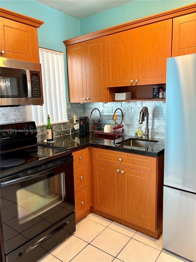 kitchen with light tile patterned flooring, sink, backsplash, fridge, and black / electric stove