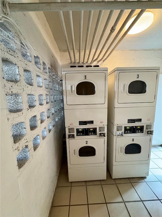 clothes washing area with light tile patterned flooring, washer and dryer, and stacked washer / dryer