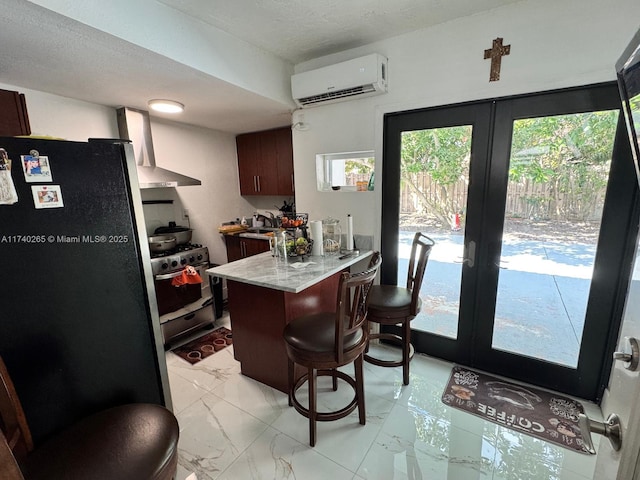 kitchen with a breakfast bar, appliances with stainless steel finishes, a wall unit AC, french doors, and wall chimney exhaust hood