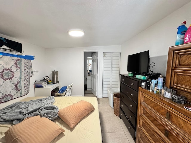 bedroom with light tile patterned floors, ensuite bath, and a closet