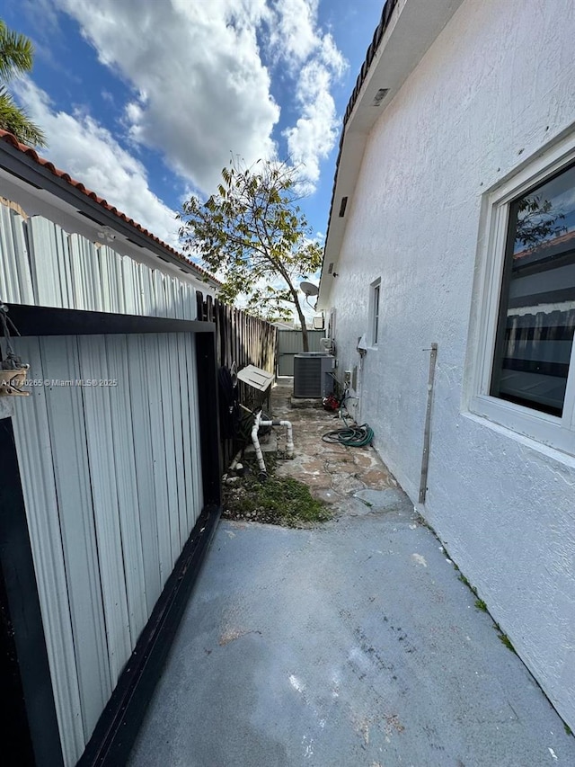 view of property exterior with central AC and a patio area