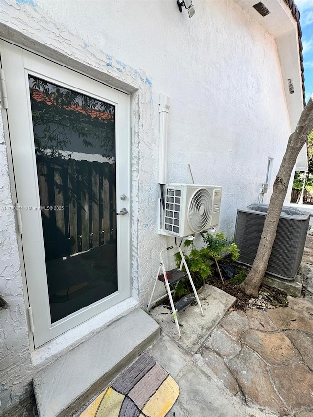 view of exterior entry with cooling unit and ac unit