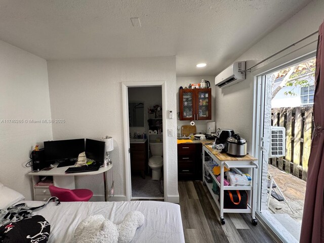 home office with sink, dark wood-type flooring, a wall mounted AC, and a textured ceiling