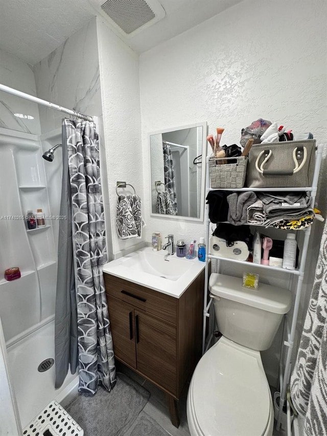 bathroom with walk in shower, vanity, and toilet