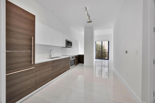 kitchen with tasteful backsplash, sink, white cabinets, light tile patterned floors, and stainless steel appliances
