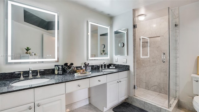 bathroom featuring a shower with door and vanity