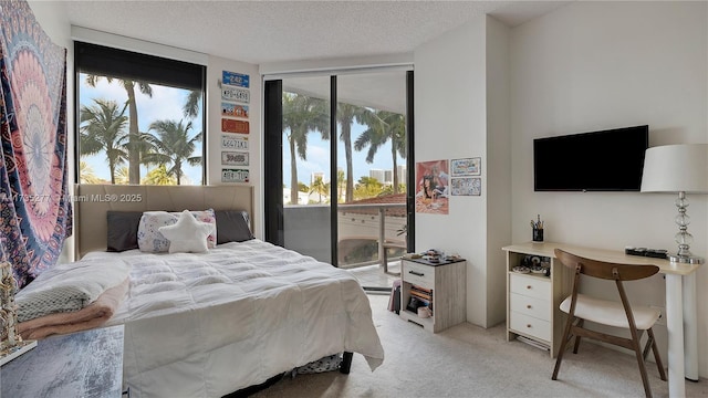 bedroom featuring access to outside, light colored carpet, and a textured ceiling