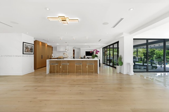 kitchen featuring light wood-type flooring, expansive windows, plenty of natural light, and a kitchen island