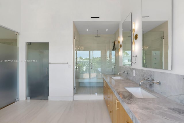 bathroom featuring vanity, an enclosed shower, and decorative backsplash