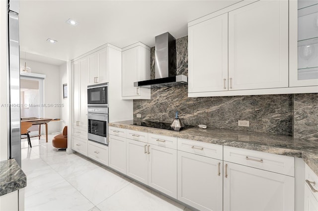 kitchen with black appliances, white cabinetry, tasteful backsplash, and wall chimney exhaust hood