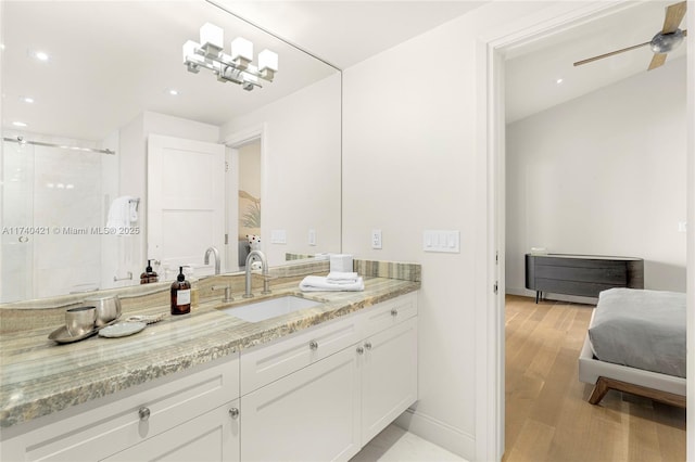 bathroom featuring walk in shower, ceiling fan, vanity, and hardwood / wood-style floors