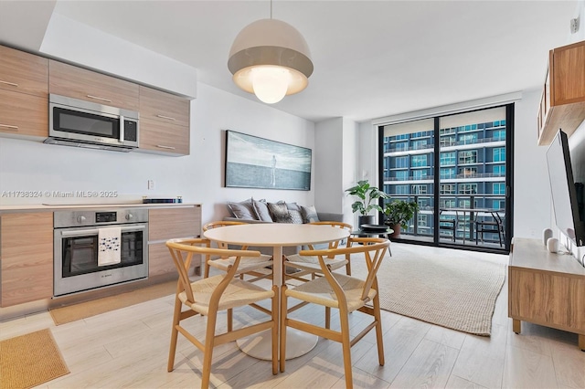 dining space featuring light hardwood / wood-style floors and expansive windows