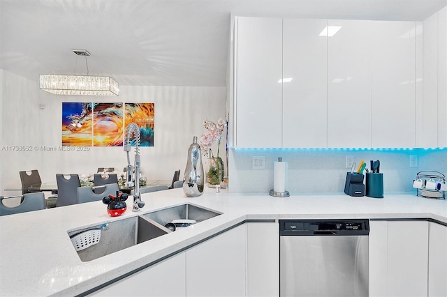 kitchen featuring dishwasher, sink, white cabinets, hanging light fixtures, and light stone counters