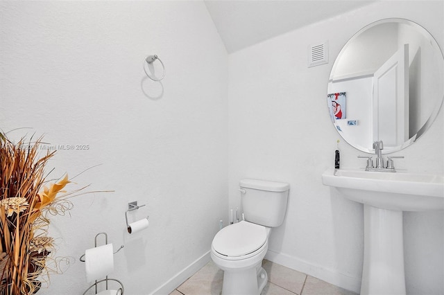 bathroom with tile patterned flooring, sink, vaulted ceiling, and toilet