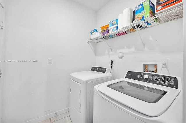 washroom with light tile patterned floors and washing machine and clothes dryer