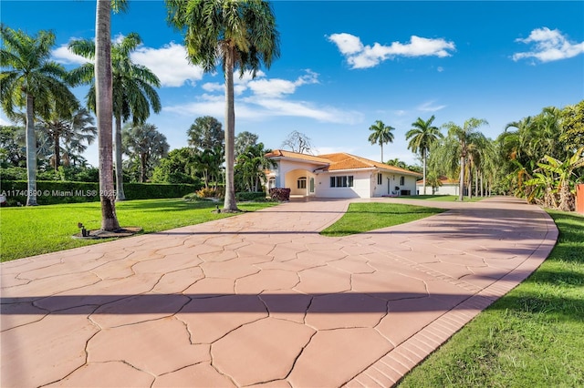 mediterranean / spanish home with a front lawn