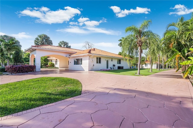 mediterranean / spanish-style home with a front lawn