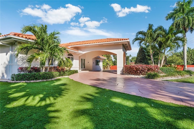 rear view of property with a carport and a lawn