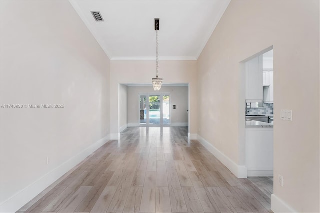 hallway featuring crown molding and light hardwood / wood-style flooring