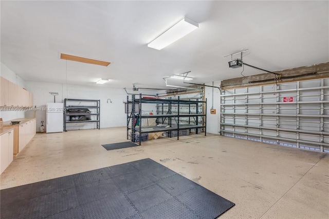 garage featuring a garage door opener and white refrigerator