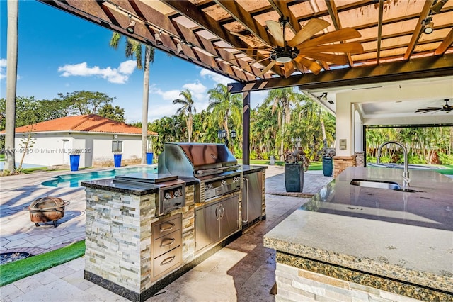 view of patio with sink, ceiling fan, an outdoor fire pit, grilling area, and an outdoor kitchen