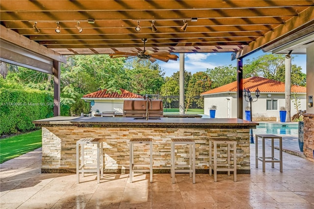 view of patio featuring ceiling fan, a grill, exterior bar, and a pergola