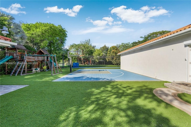 view of sport court featuring a yard and a playground