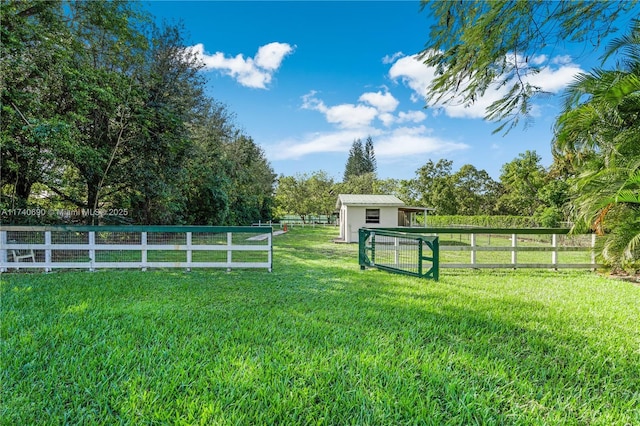 view of yard with an outdoor structure and a rural view