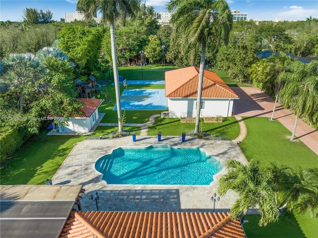 view of swimming pool featuring an outdoor structure and a lawn