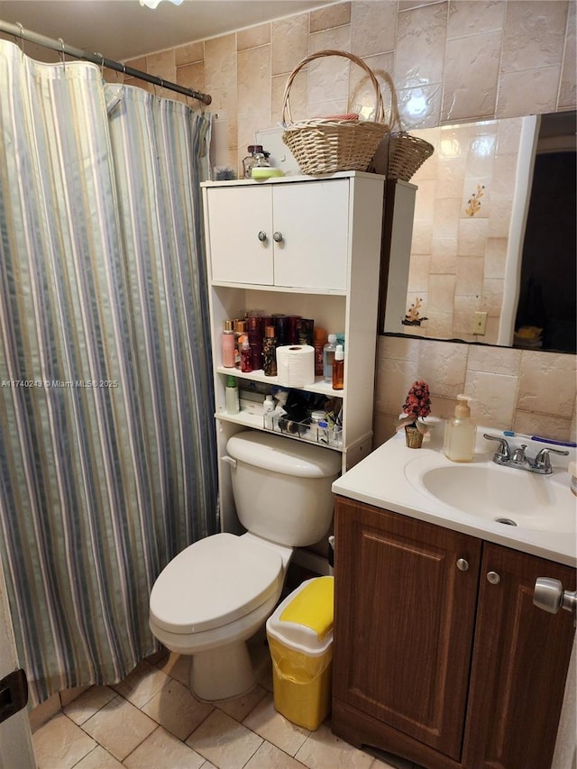 bathroom with toilet, tile walls, vanity, tile patterned flooring, and decorative backsplash