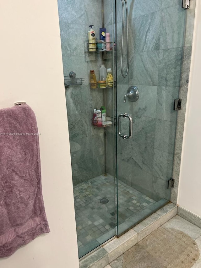 bathroom with a shower with shower door and tile patterned floors