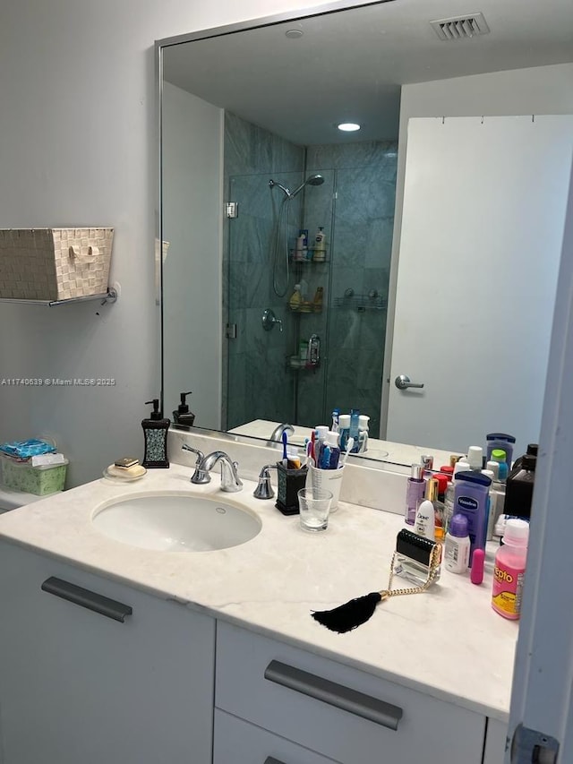 bathroom with vanity and a shower with shower door