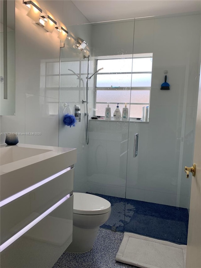 bathroom featuring vanity, an enclosed shower, and toilet