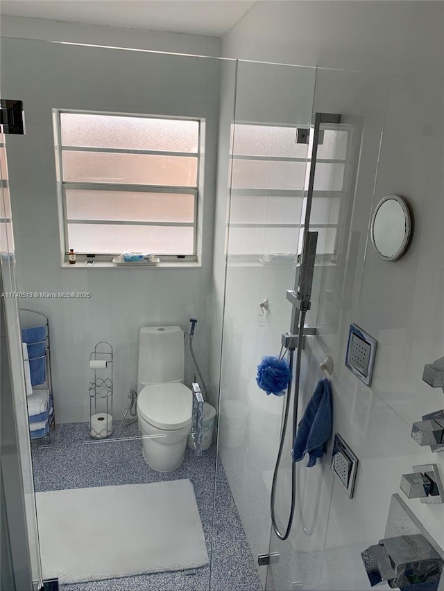 bathroom with toilet and a shower stall