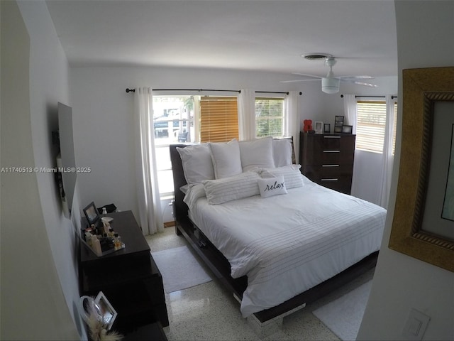 bedroom with light speckled floor and multiple windows